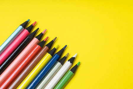 colored pencils on a yellow background