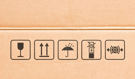 Side of real cardboard box with black various fragile symbolの写真素材