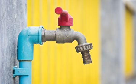 worn out faucet on fence
