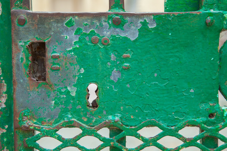 A green rusty lock on an iron doorの写真素材