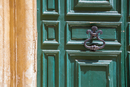 A wood green door with knob close to a yellow wallの写真素材