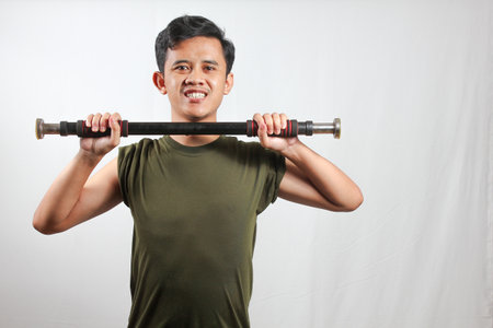 asian man lifting light dumbbells isolated on white backgroundの写真素材