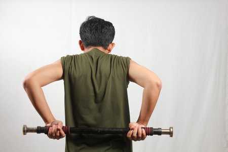 Back view of asian man exercising with barbell on white background