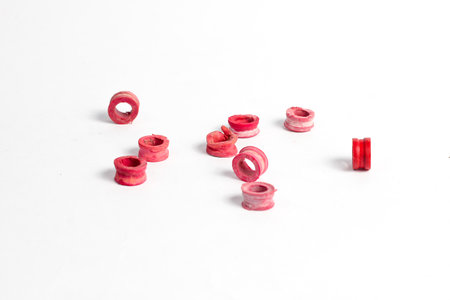 A collection of scattered gas cylinder regulator seals isolated on a white background