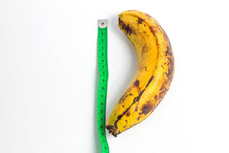 Banana and measuring tape isolated on white background. Diet concept.