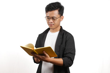 Young Asian man reading a book on white background. Education concept.