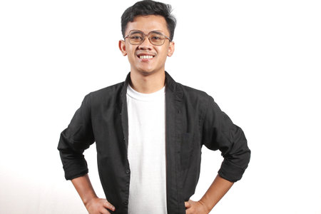 Young Asian man in a black jacket and glasses isolated on white background.の写真素材