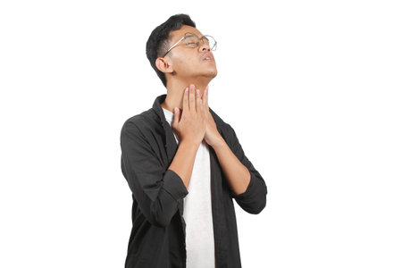 Portrait of a young Asian man suffering from throat pain isolated on white background