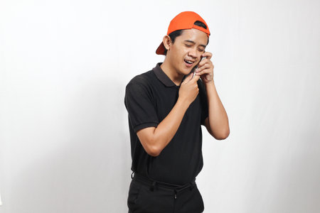 Portrait of young asian man talking on the phone on white background