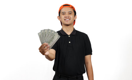 Portrait of a happy young asian man holding money isolated on white background