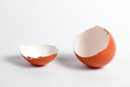 Broken eggshell isolated on white background. Close up shot.