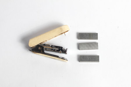 Old stapler and staples on white background, top view.の写真素材
