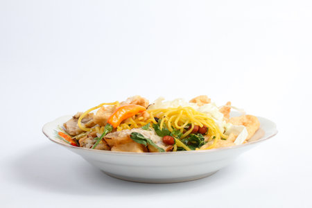 Fried noodle with pork and vegetable in white plate on table