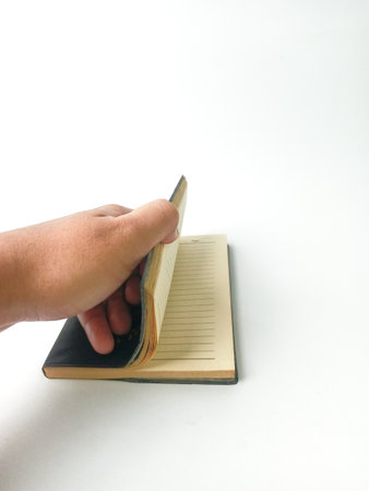 Hand holding a book isolated on white background, close up of handの写真素材