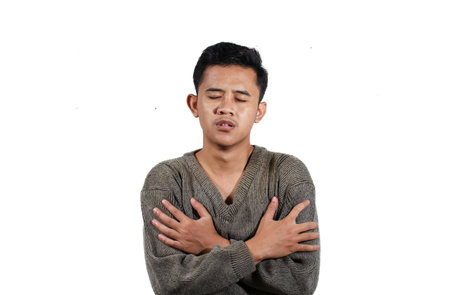 Young Asian man suffering from stomach ache isolated on white background.