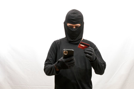 A person holds a credit card and phone.
