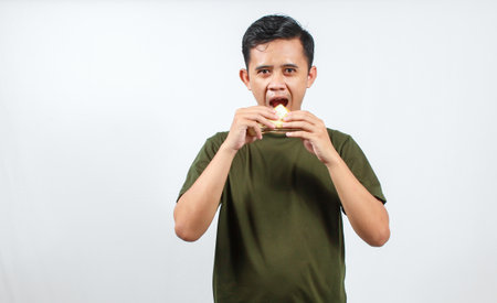Young Asian man eating on white background. Healthy food concept.