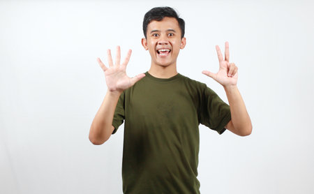 Portrait of a young Asian man showing hand sign isolated on white background