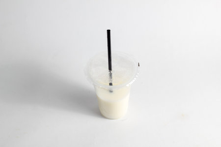 Milkshake in plastic cup with straw on white background, stock photoの写真素材