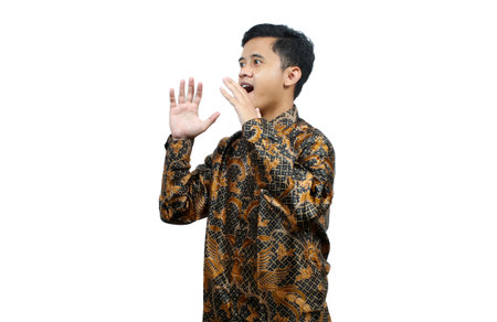 Young Asian man wearing a kebaya is surprised and shocked, isolated on white background.の写真素材
