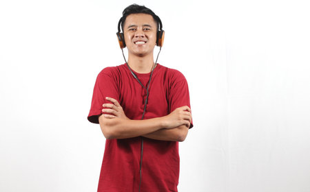 young asian man with headphones listening to music on white background.