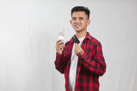 Portrait of young asian man holding card on white backgroundの写真素材