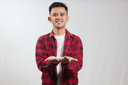 Young asian man holding something on white background.の写真素材