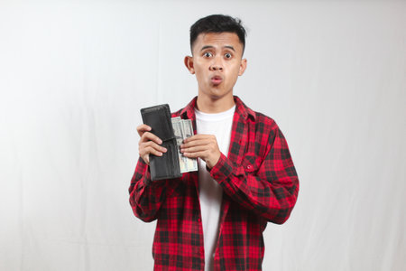 Young asian man in red and black plaid shirt holding wallet on white background