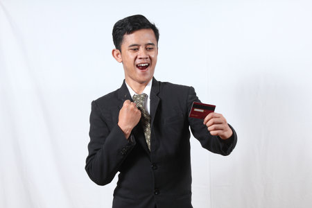 Young asian business man holding a credit card on white background.