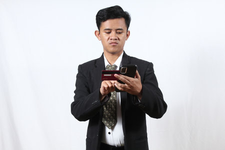 Young Asian businessman using mobile phone and credit card on white background.