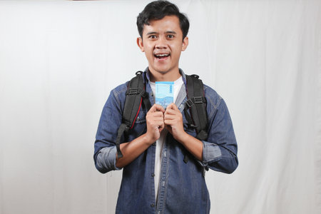 Portrait of a happy young asian man with backpack