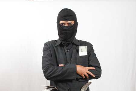 Young asian man wearing a balaclava with money on white background