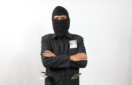 asian man wearing a balaclava and holding money on white background