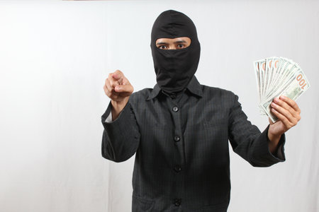 man wearing balaclava and holding money on white background