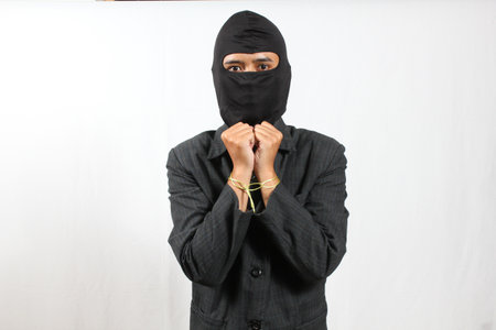 Young asian man wearing a balaclava over white backgroundの写真素材