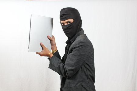 businesswoman wearing a mask and holding a laptop on white backgroundの写真素材