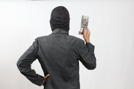 Rear view of a young asian man wearing a suit with moneyの写真素材
