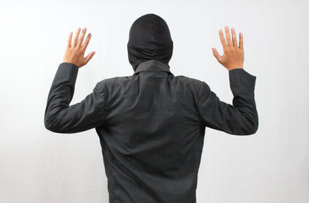 Back view of asian business man in suit with hands up on white backgroundの写真素材