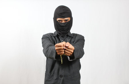 man wearing mask and black suit caught tied with small rope isolated on white backgroundの写真素材