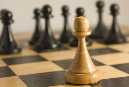 The white pawn resists to black pawns and is on crossing of squares. Against rulesの写真素材