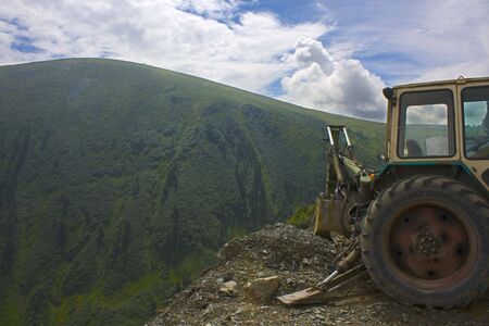 Part of a dredge on a background of a mountain landscape. The beautiful sky. Mountain on a background, cut up by rivulets and cleftsの写真素材
