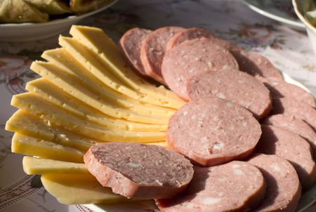 Sausage and cheese are cut on a plateの写真素材