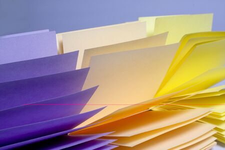 opened stack of notes different colors on blueの写真素材