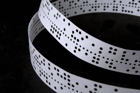 The punched tape on a black background lays ringsの写真素材