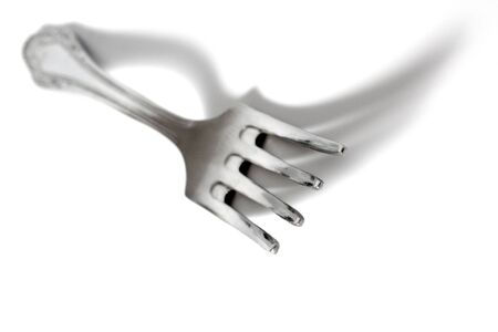 stainless fork on white table with shadows
