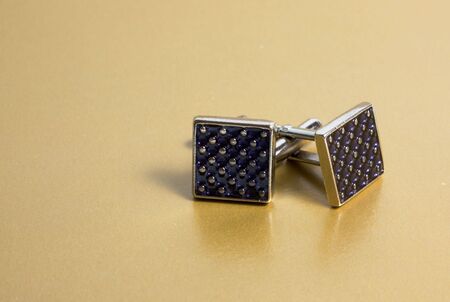 stainless steel cufflinks on the gold backgroundの写真素材