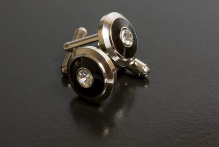 stainless steel cufflinks on the black backgroundの写真素材