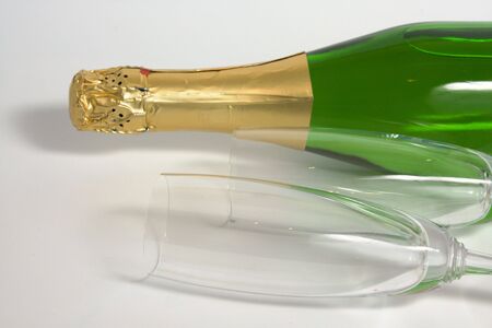 The closed bottle of champagne without a label and two wineglassesの写真素材