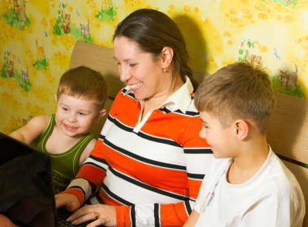 mother and  sons looks on laptop  joying and smilingの写真素材