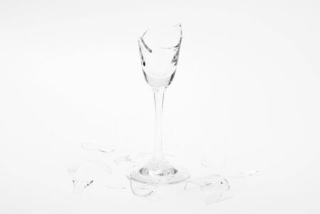 Broken wineglass on the white background. Black and white.の写真素材